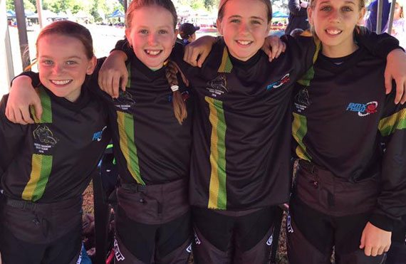 Four smiling girls in matching athletic outfits for Australian BMX Mighty 11s, showcasing Planett Active Range