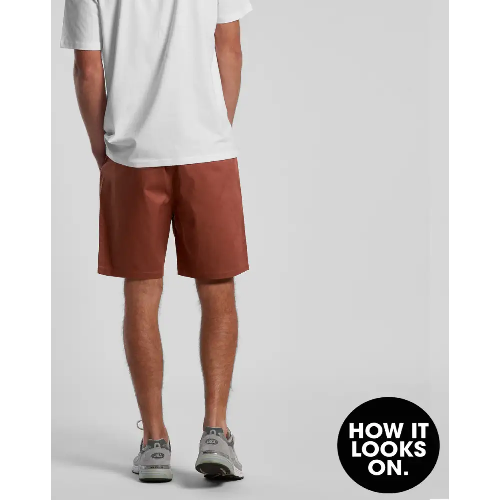 Man wearing brown shorts and a white t-shirt.