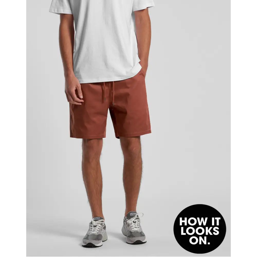 Man wearing white t-shirt and brown shorts.
