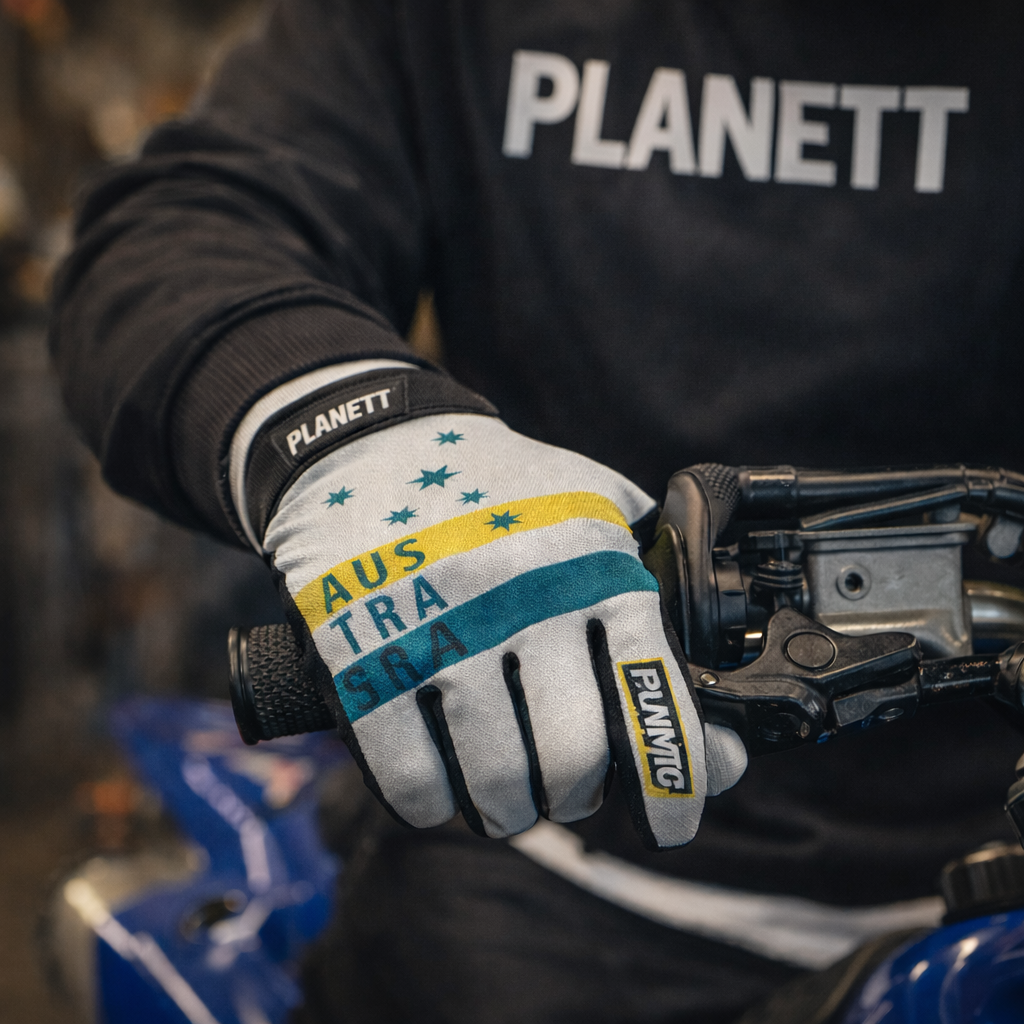 White motorcycle glove with yellow and teal stripes, star patterns, and ’australia’ text, branded planett.