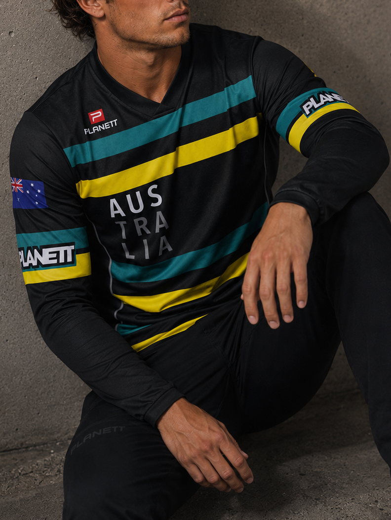 Man wearing a sports jersey with Australia branding against a concrete wall.