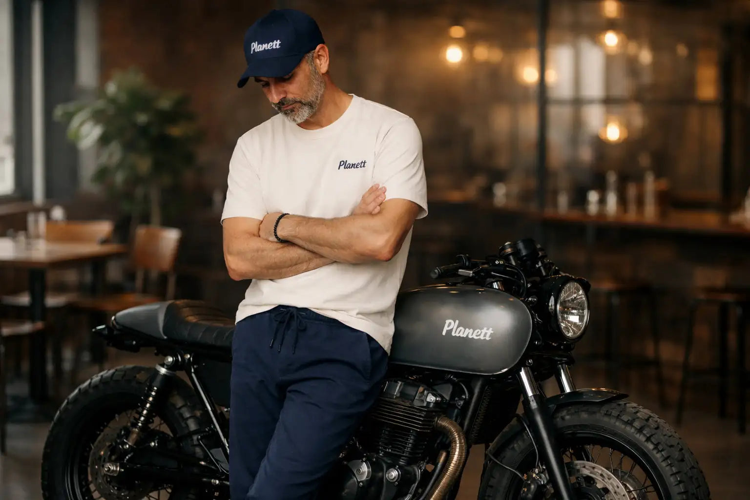 Black matte-finished motorcycle with ’planett’ branding on the fuel tank and cap.