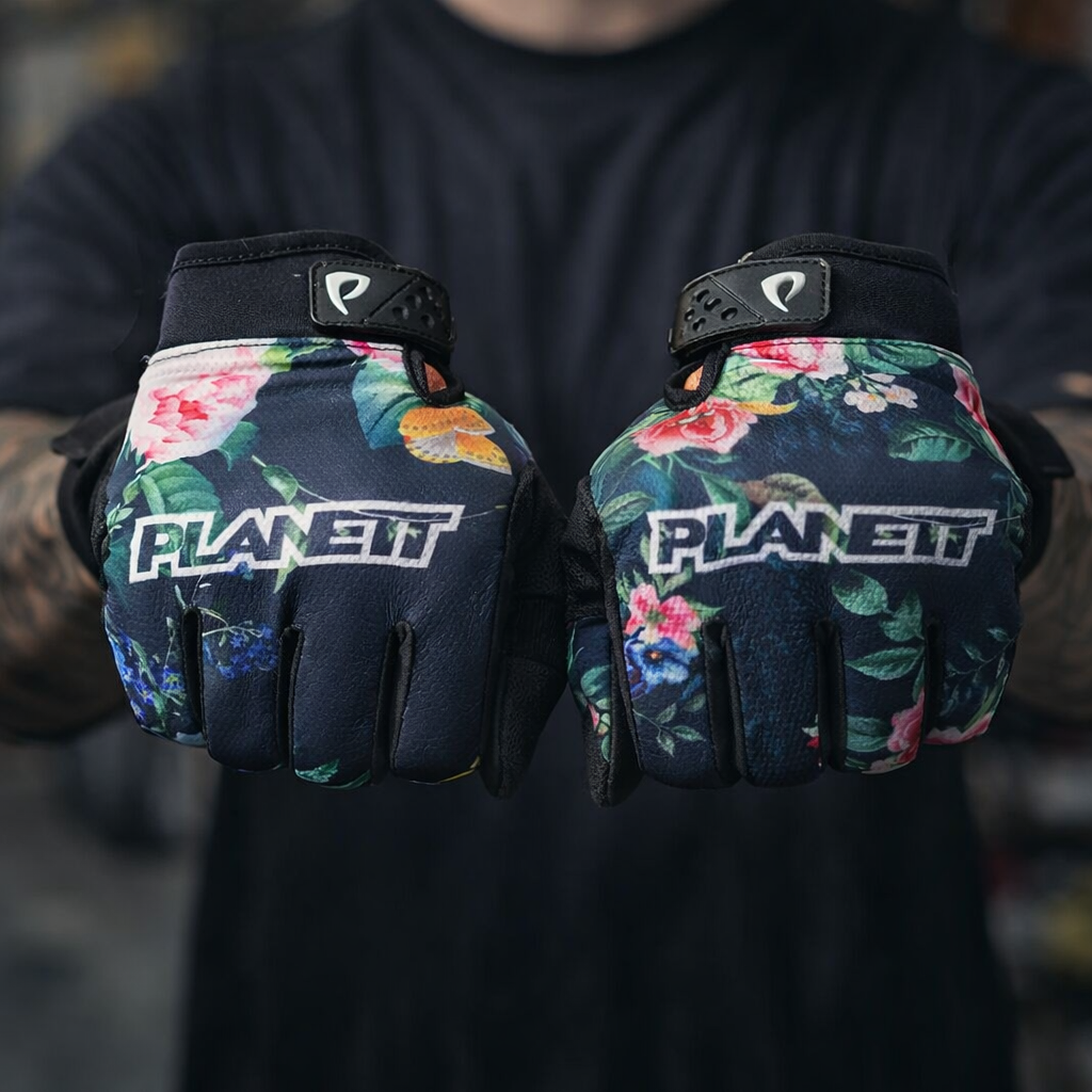 Dark blue floral-patterned planet gloves with vibrant pink, red, and green flowers.