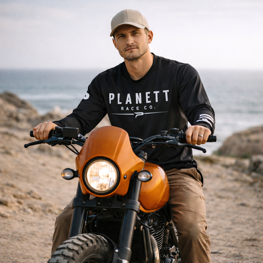 Orange custom-built motorcycle with a round headlight and black handlebars