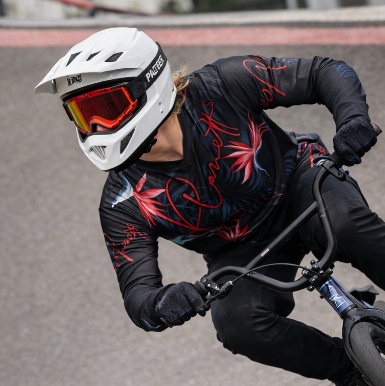 White panter helmet with red-tinted goggles and black straps.