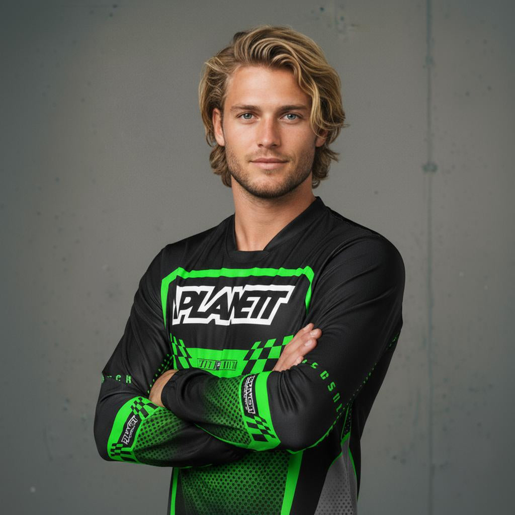 A man with blonde hair and a beard wearing a black and green long-sleeved athletic shirt.