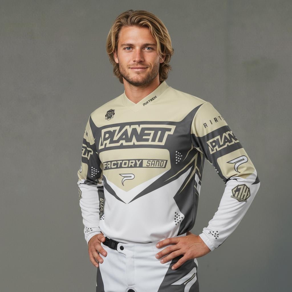 A man modeling a long-sleeved motocross jersey and matching pants.
