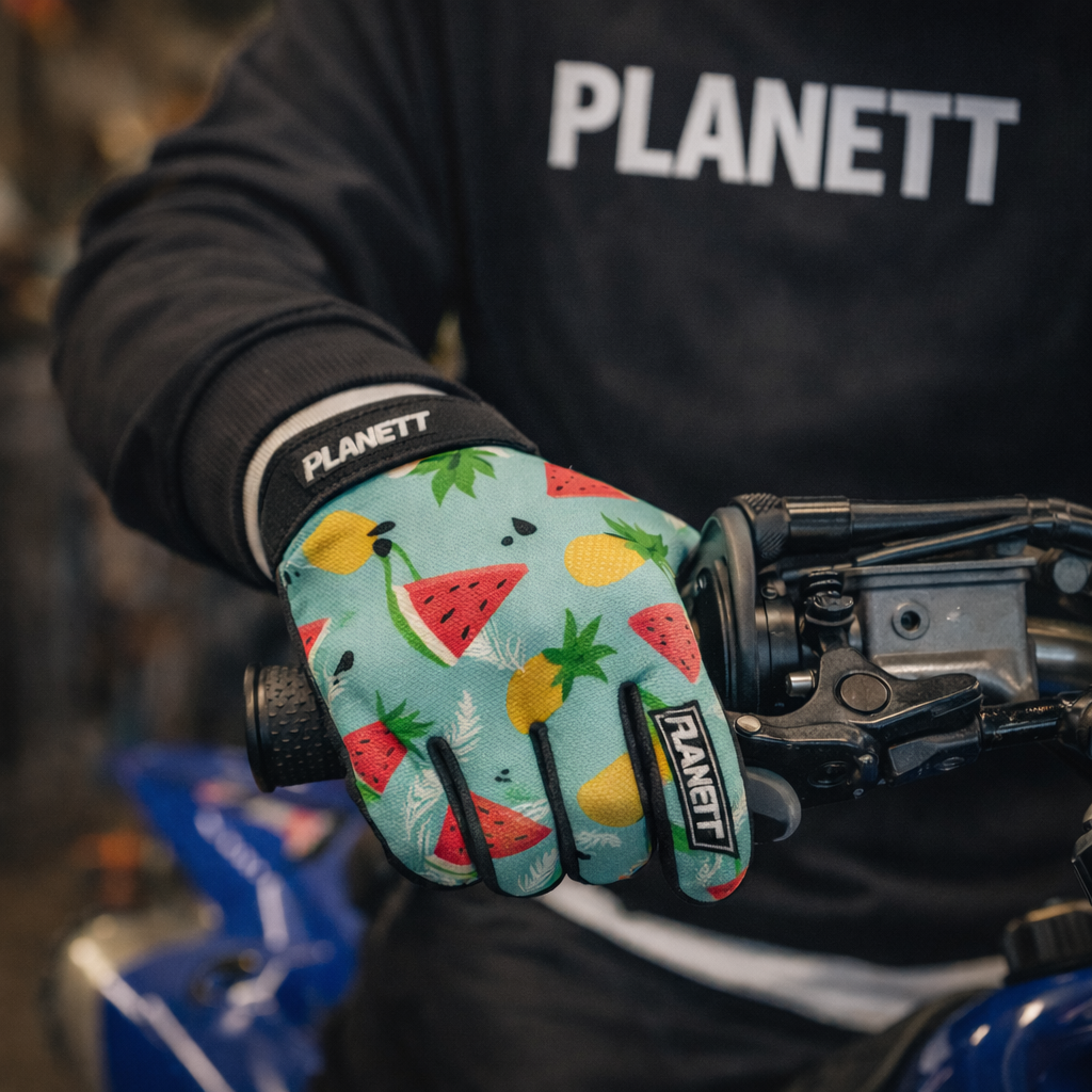 Light blue planett cycling glove with a playful tropical fruit pattern featuring watermelon slices and pineapples.