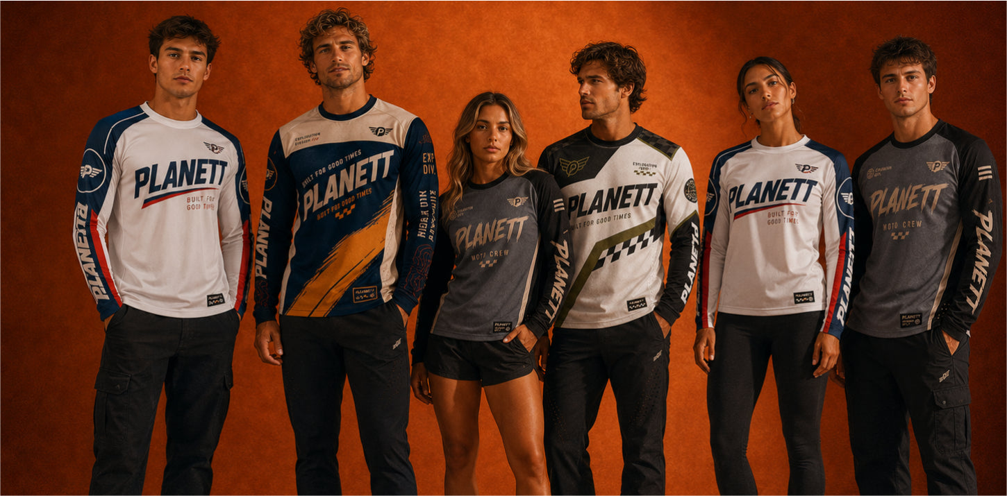 Six people standing together and wearing matching Planet F1 team apparel in white, gray, and navy jerseys against a warm orange studio background.