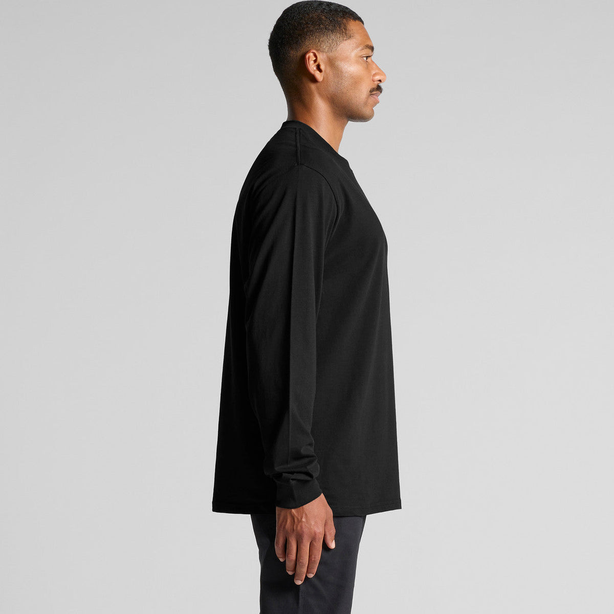 Black long-sleeve shirt with relaxed fit and ribbed cuffs, made of cotton.