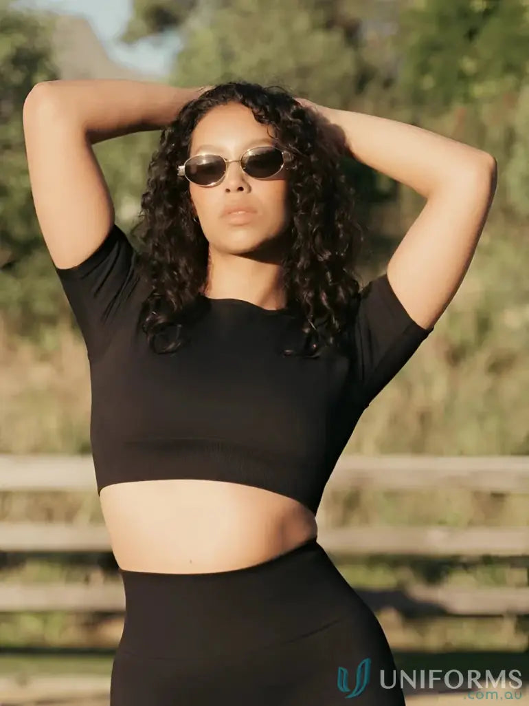 Black cropped athletic top with a ribbed texture and short sleeves.