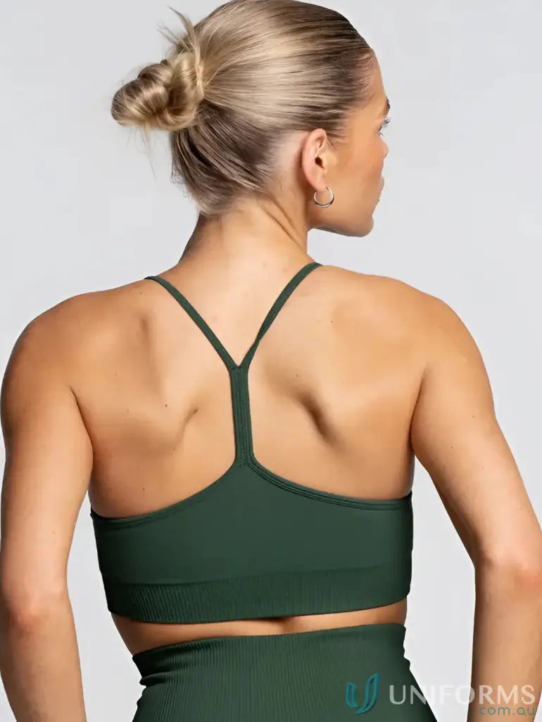 Dark green sports bra with crisscross back design and thin straps.