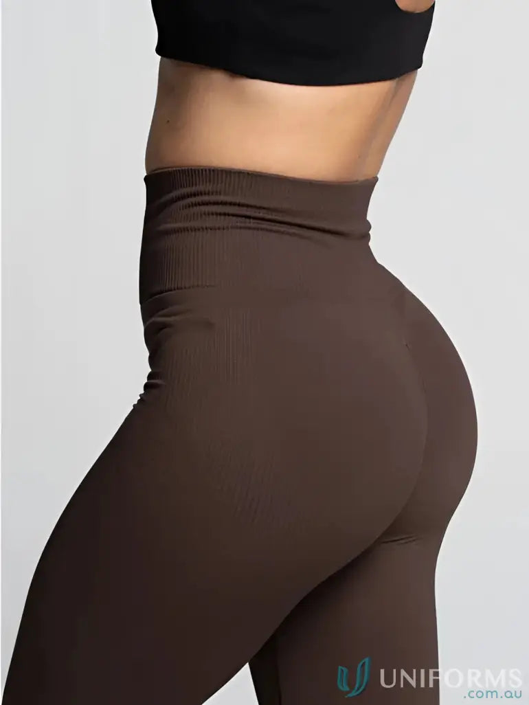 Brown high-waisted leggings with a ribbed waistband and side pockets.