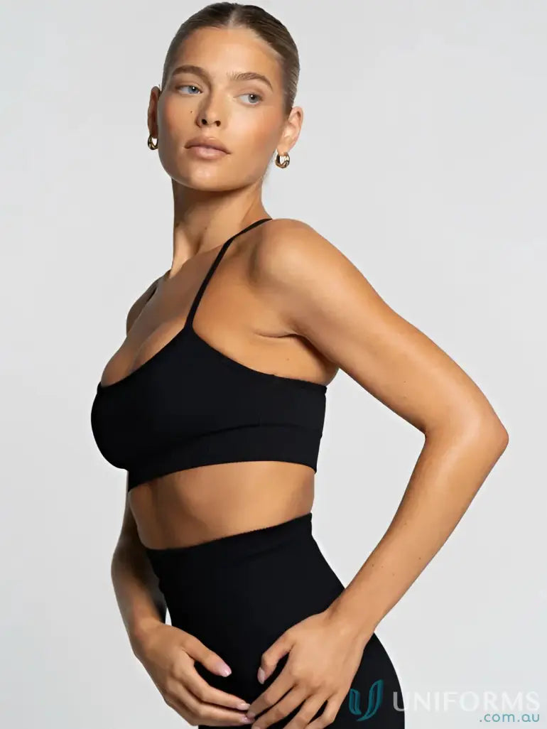 Black sports bra with thin straps and a scoop neckline.