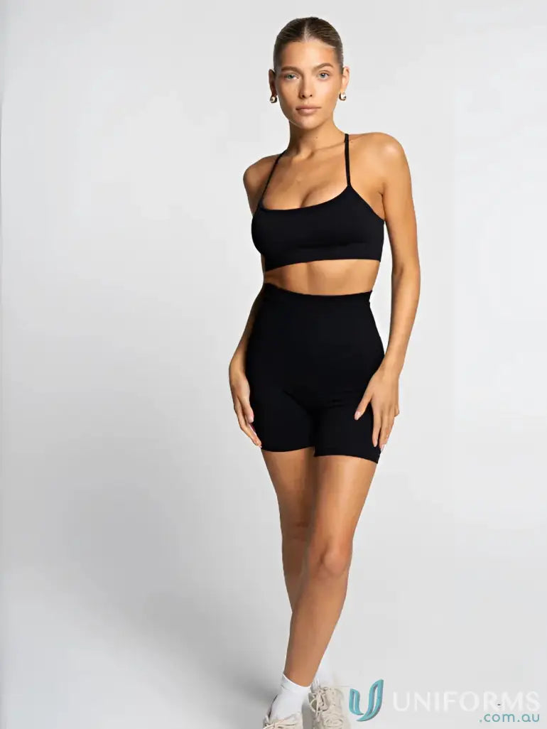 Black athletic two-piece set with matching sports bra and shorts, made of stretchy fabric for comfort.