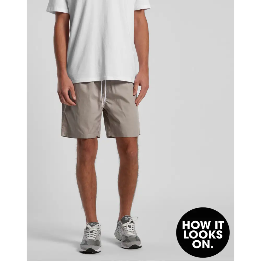 Man wearing beige shorts and gray sneakers.