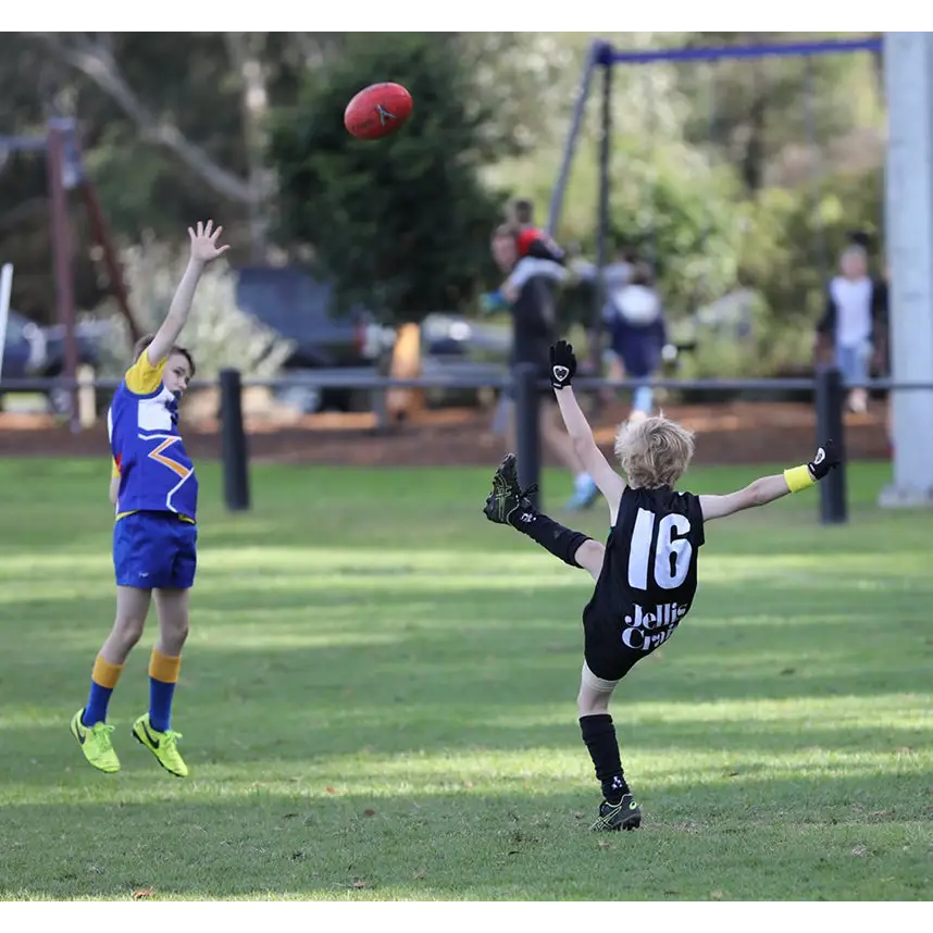 Children playing Australian Rules Football.