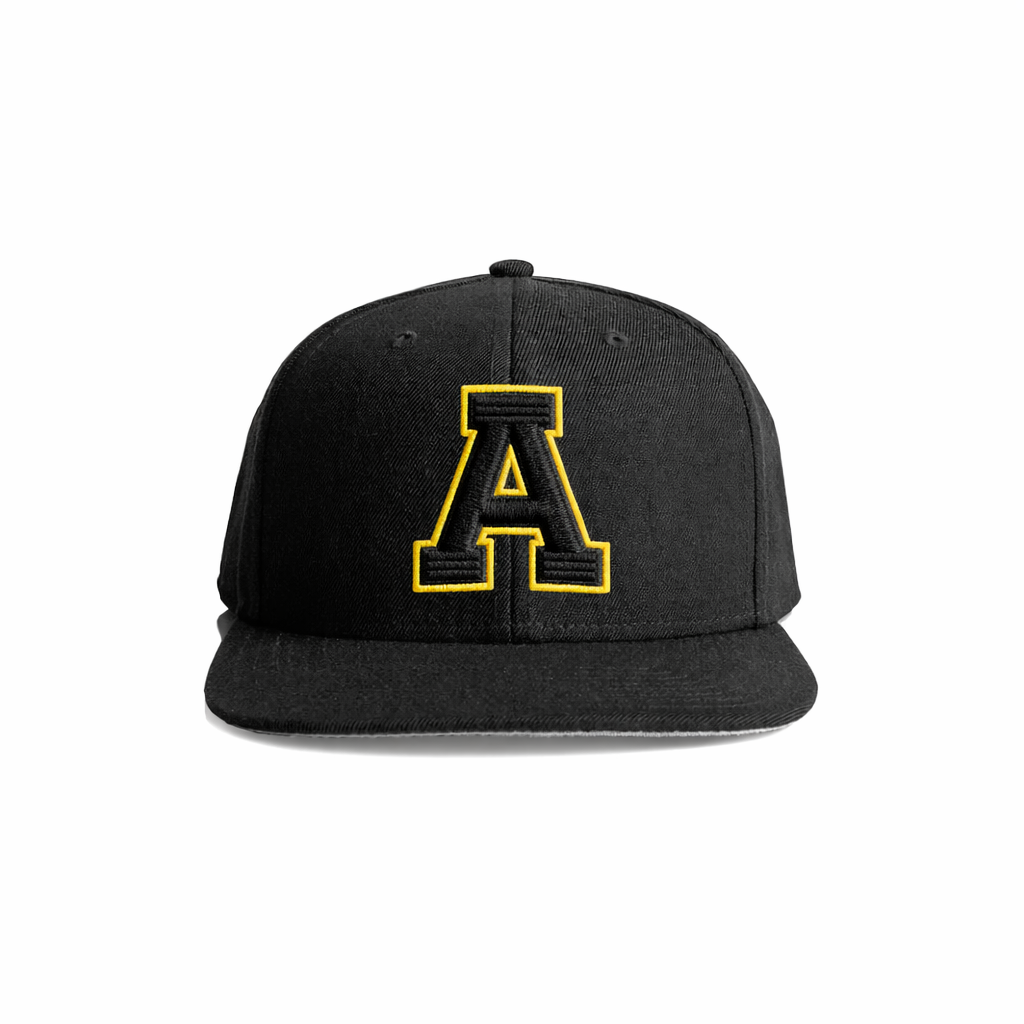 Black snapback cap with a bold yellow embroidered letter ’a’ on the front.