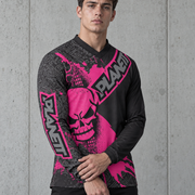 A man wearing a long-sleeve motocross jersey with a black and neon pink graphic design featuring a skull and the brand name 'PLANET'.