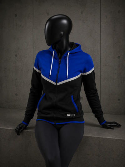 A black and blue zip-up hoodie with white drawstrings and white contrast stripes, displayed on a black mannequin against a gray concrete wall.