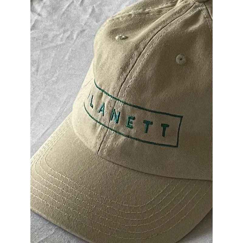 Tan baseball cap.