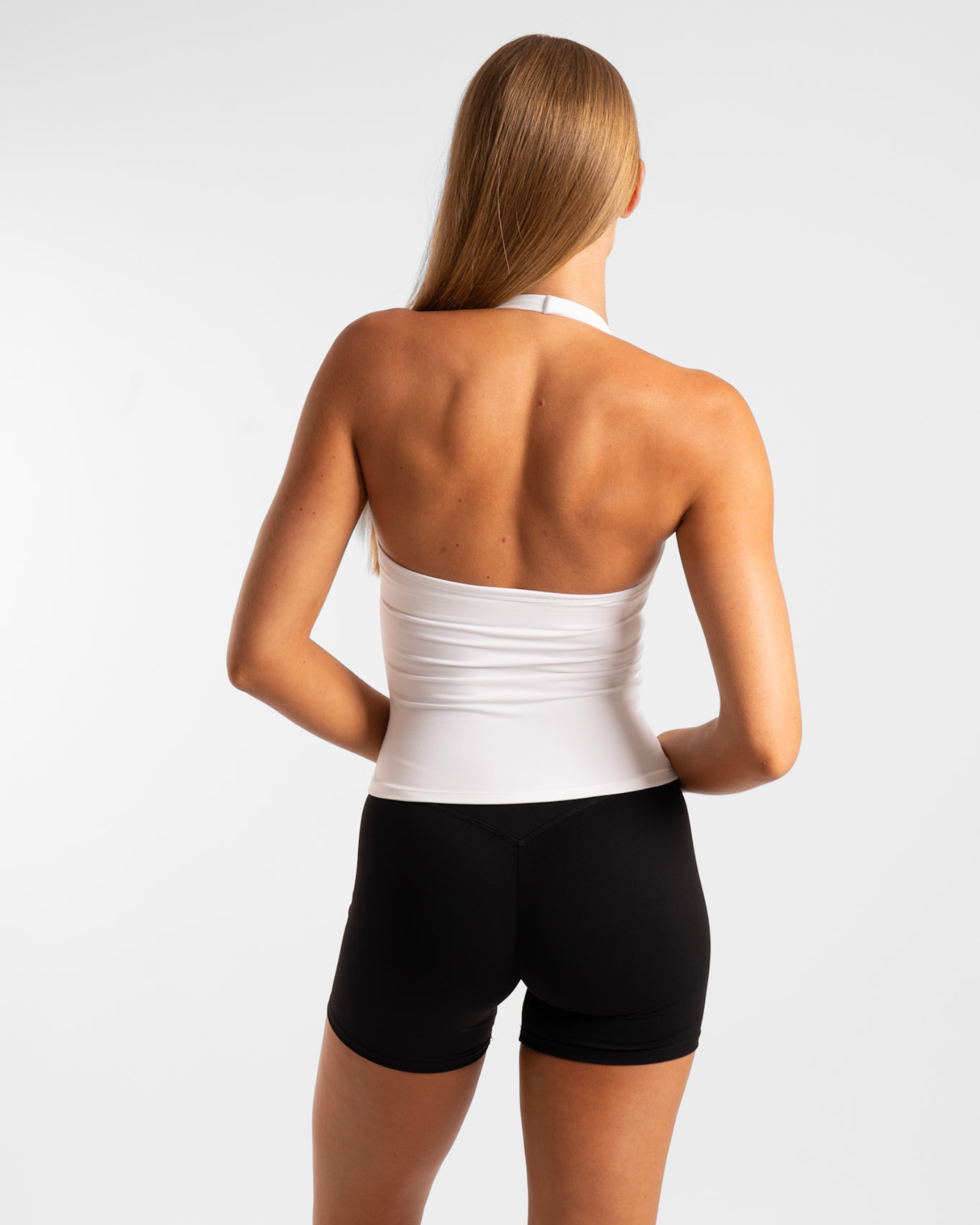 White strapless tank top with black shorts and a fitted waistband.