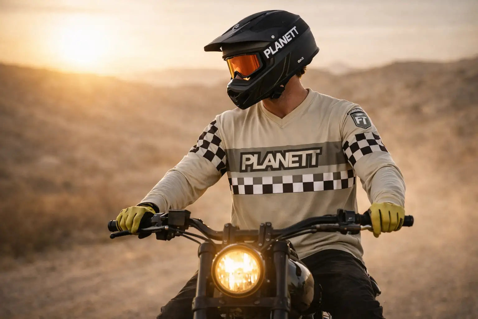 Black planett motocross helmet with orange-tinted visor.