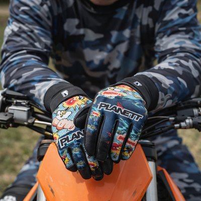 Blue and black comic book-themed motorcycle gloves with vibrant yellow, red, and white graphics.