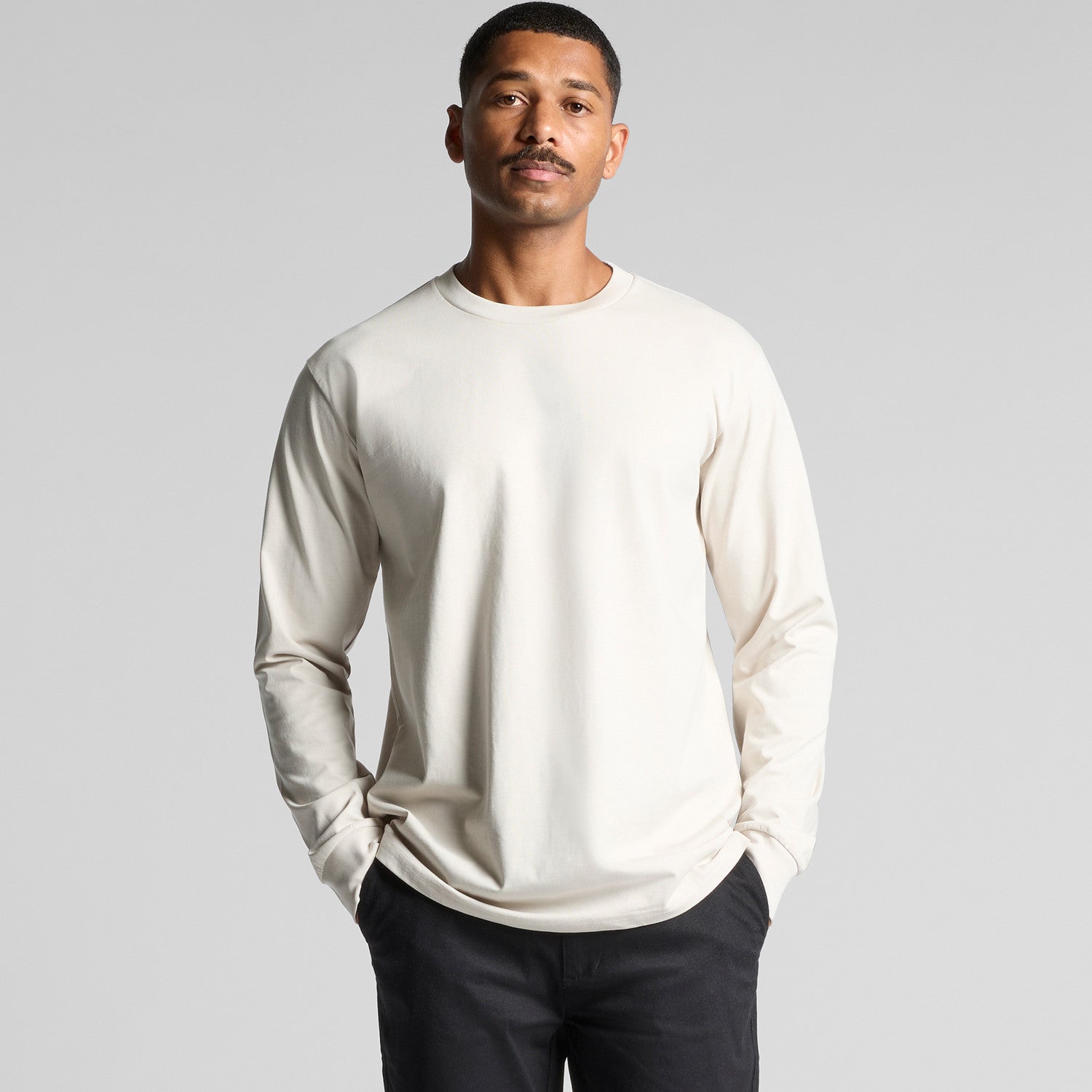 Cream-colored crew neck long-sleeve t-shirt with ribbed cuffs and hem, made of soft cotton.
