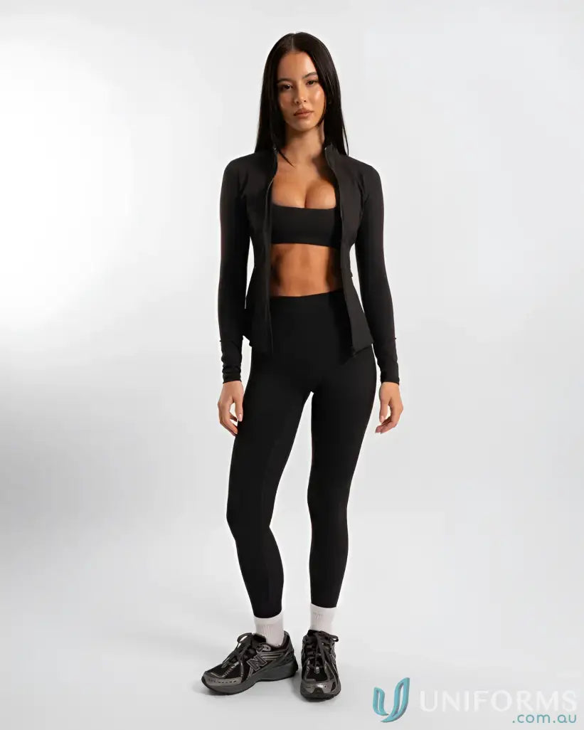 Black leggings with a high waist and ribbed texture, paired with a matching long-sleeve crop top.