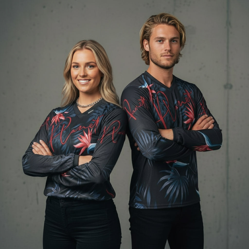 Two individuals wearing matching dark long-sleeved shirts with a tropical floral pattern.