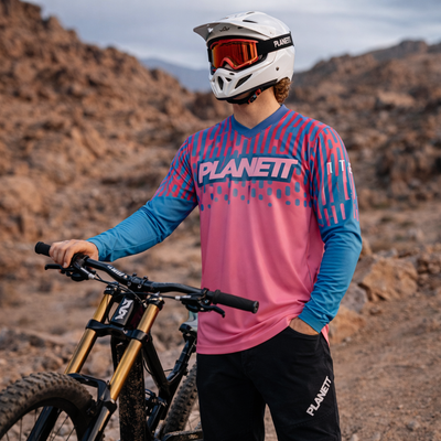 White helmet with orange goggles and black strap, featuring a sleek aerodynamic design.