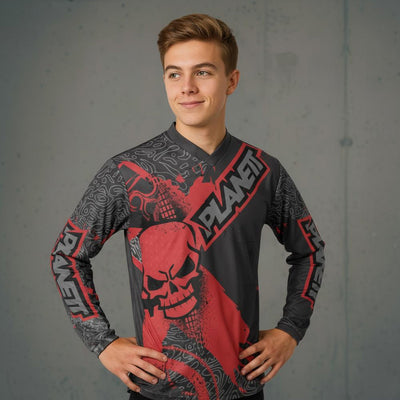 A young man wearing a long-sleeved gray and red graphic print shirt.