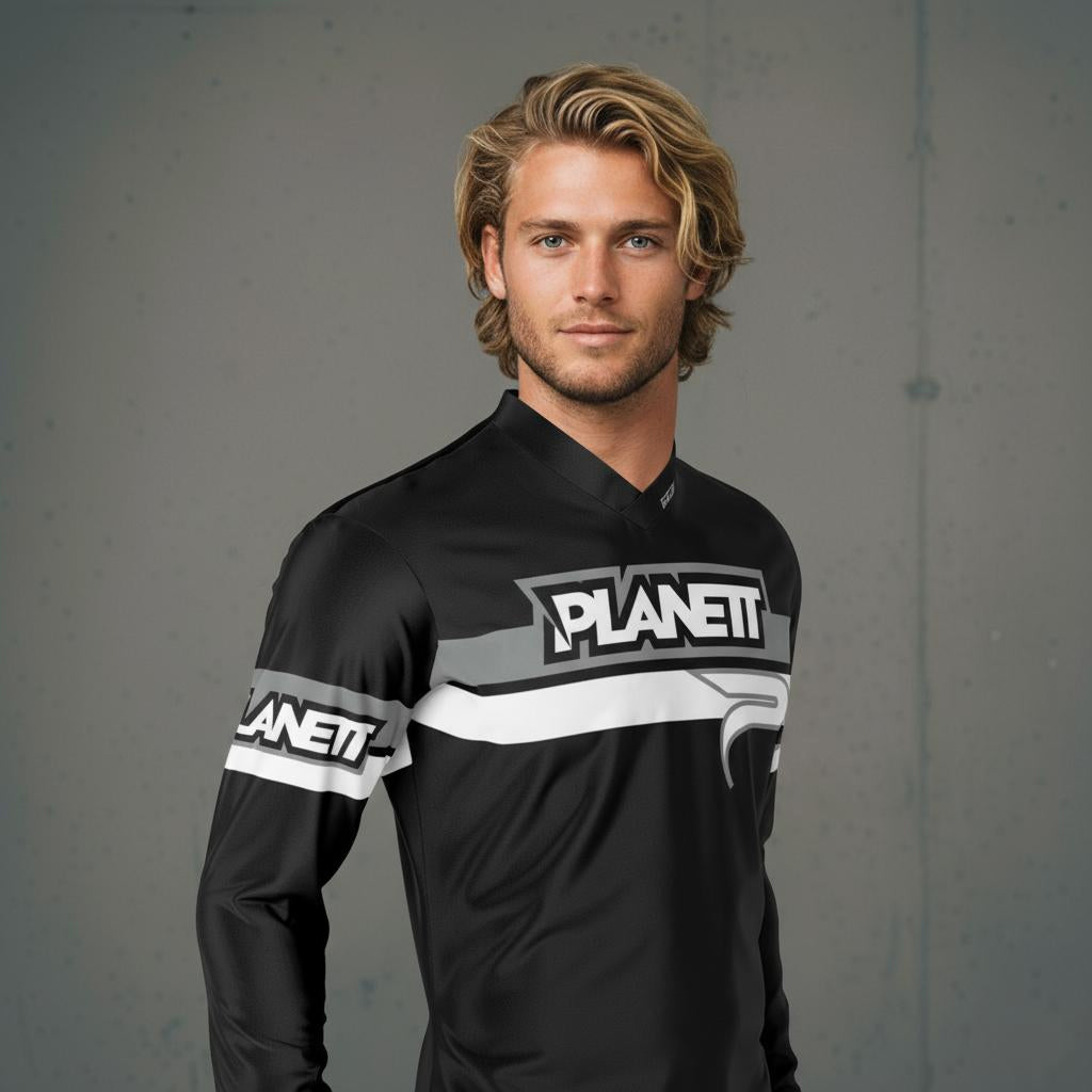 A man modeling a black, gray, and white long-sleeved athletic jersey.