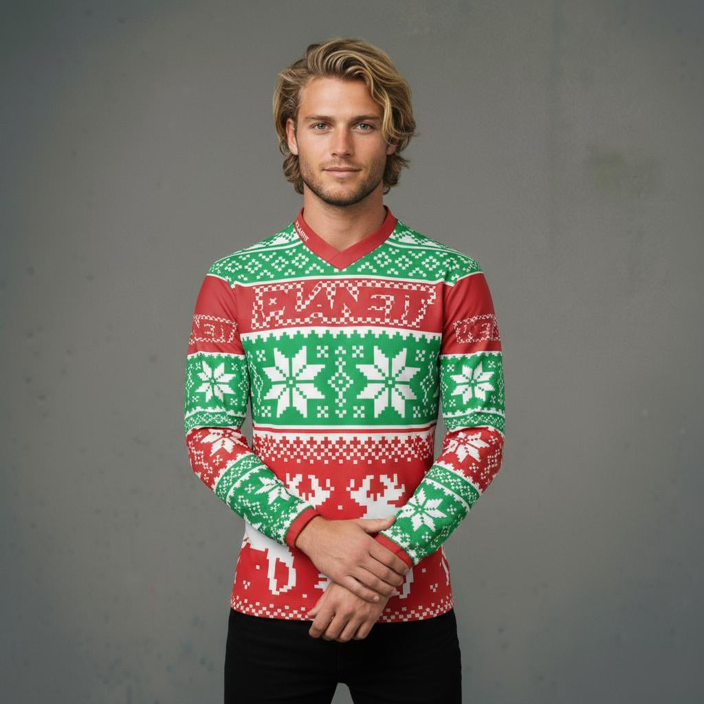 A man in a festive red and green long-sleeved Christmas-themed shirt with snowflake and reindeer patterns.