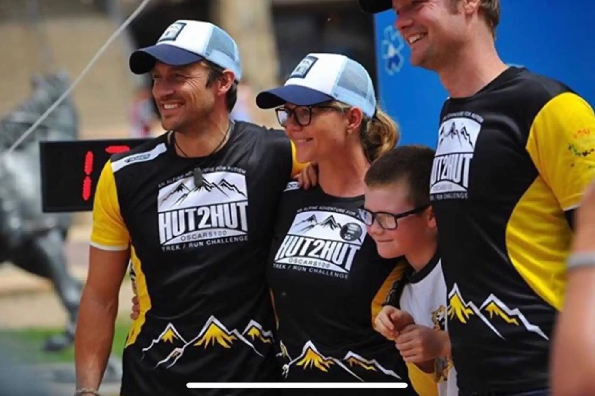 Group of people wearing matching shirts and hats.