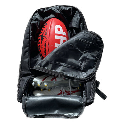 Red kangaroo brand football with white lettering and black stitching, nestled inside a black backpack.