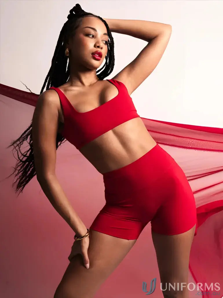 Red athletic two-piece set with high-waisted shorts and sports bra, likely made of stretchy fabric.