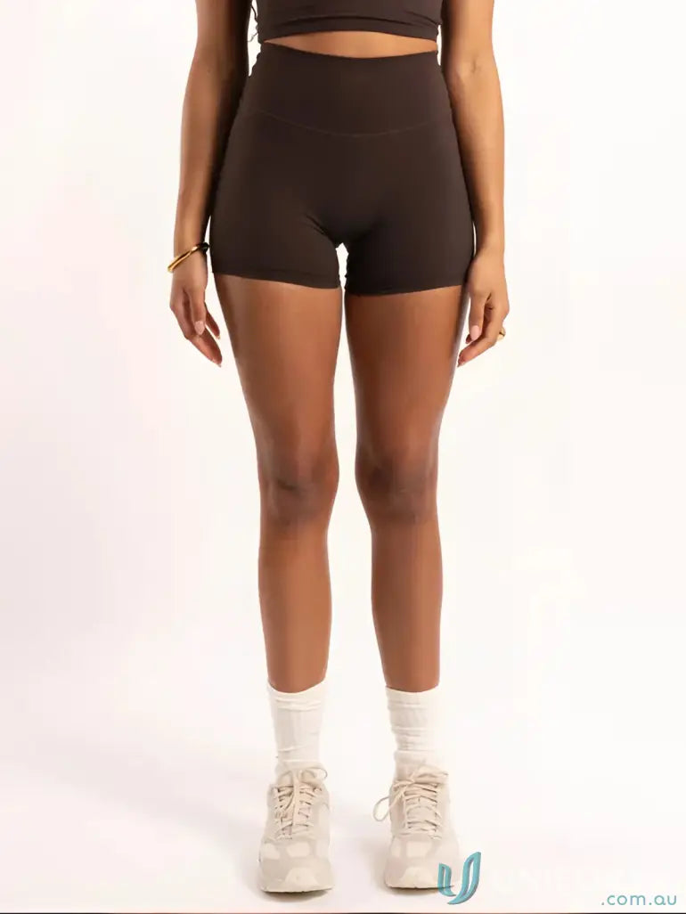 Brown high-waisted shorts with white socks and chunky sneakers.