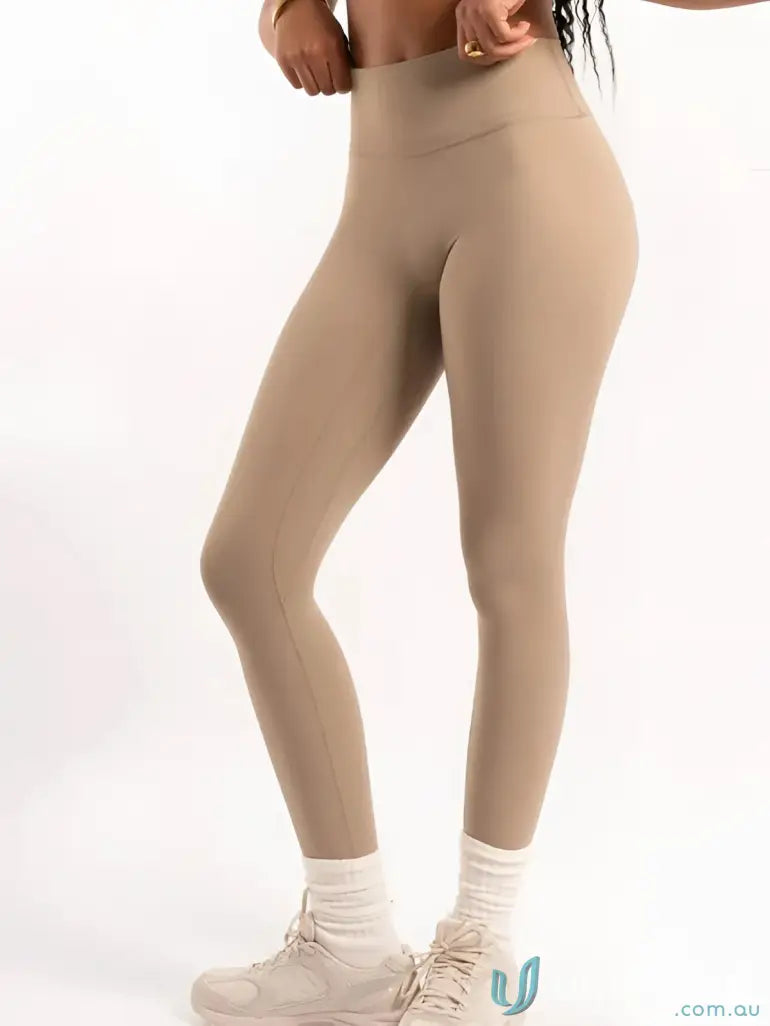 Beige leggings with high waistband and white sneakers.