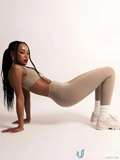 Beige seamless leggings with white sneakers and gold hoop earrings.