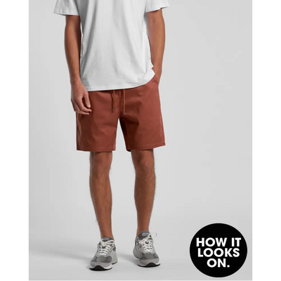 Man wearing white t-shirt and brown shorts.