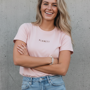 A woman in a light pink t-shirt and light wash jeans.