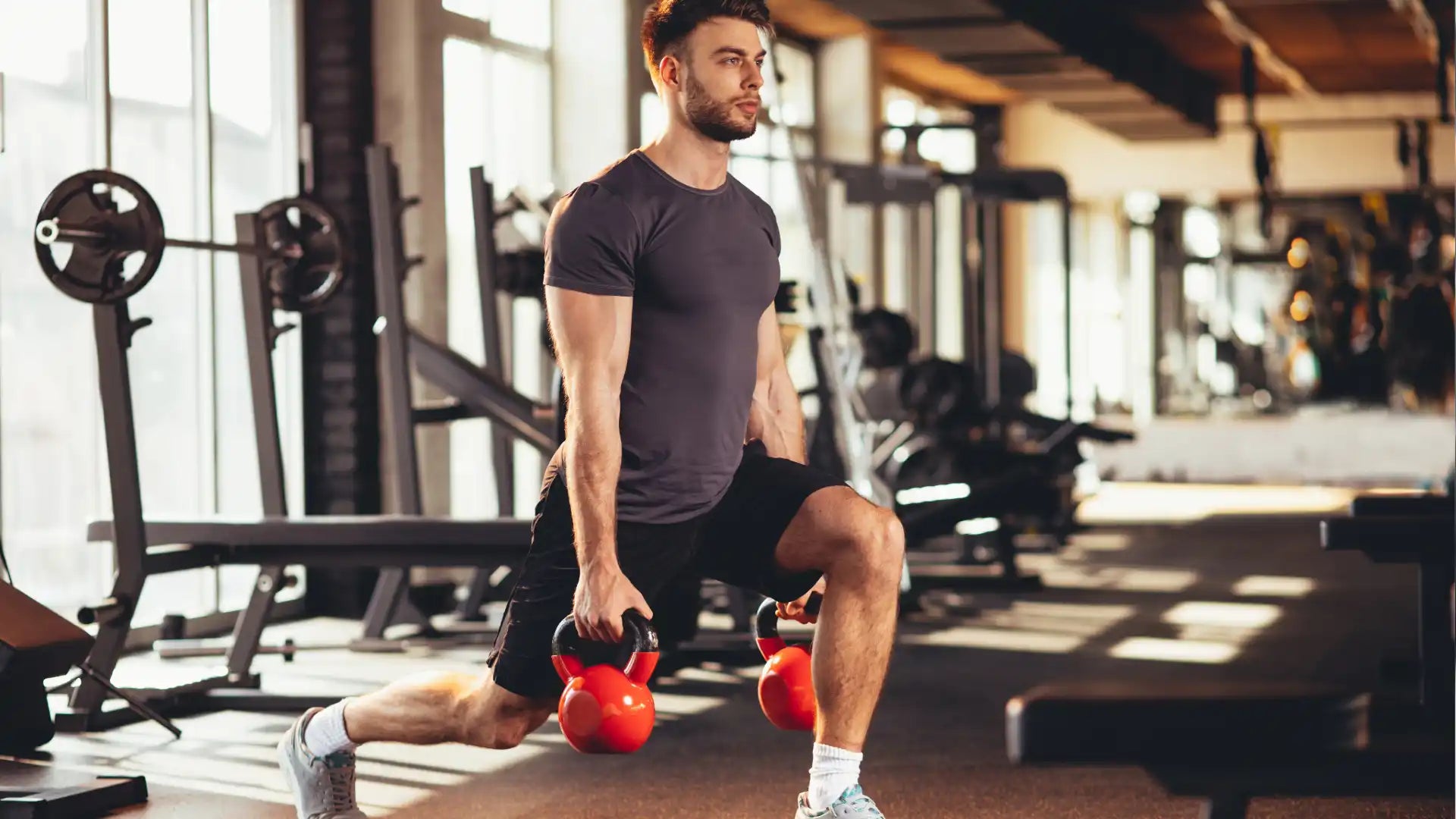 Man doing lunges with kettlebells.