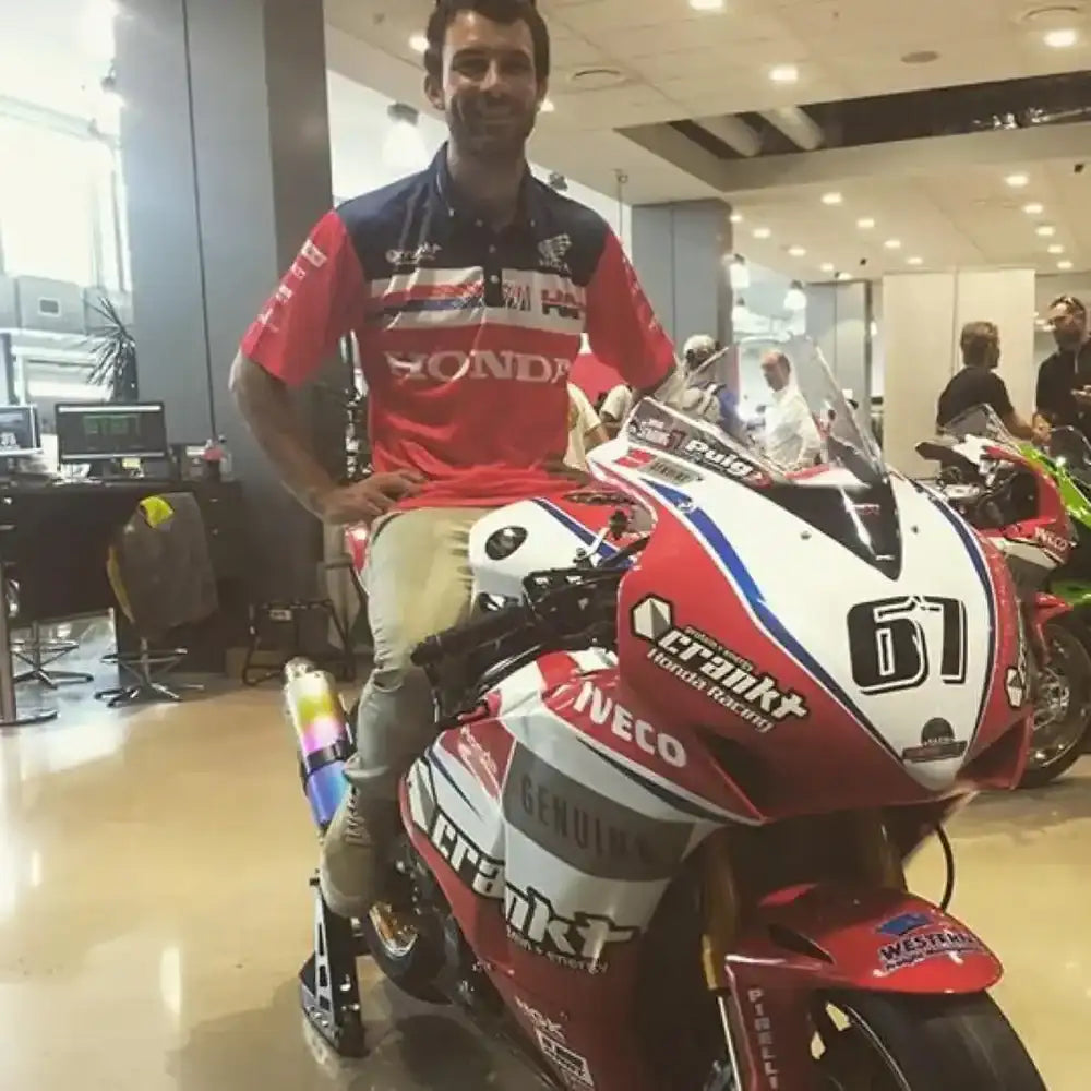 Red, white, and blue racing motorcycle with sponsor decals including ’honda,’ ’crank,’ and ’ineco.’