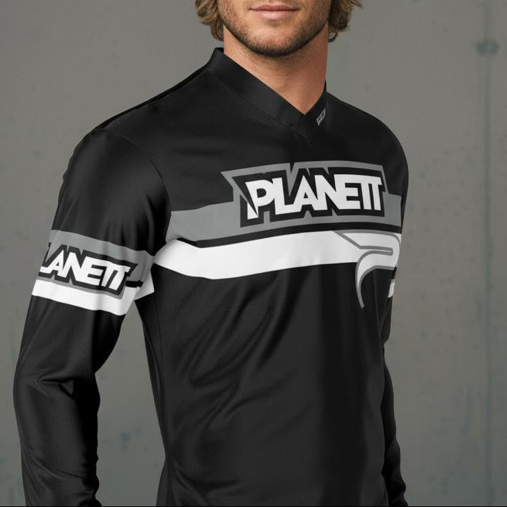 A blonde-haired man wearing a black, gray, and white long-sleeved athletic shirt.