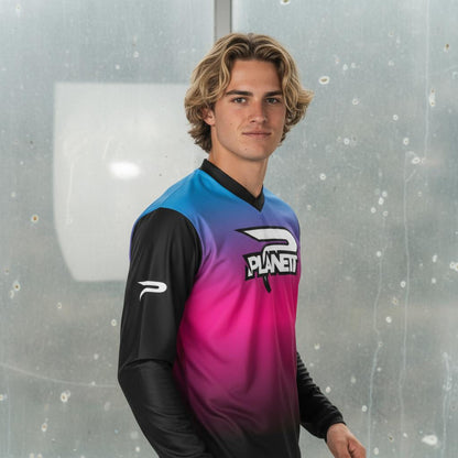 A young man wearing a black, blue, and pink long-sleeved athletic jersey.