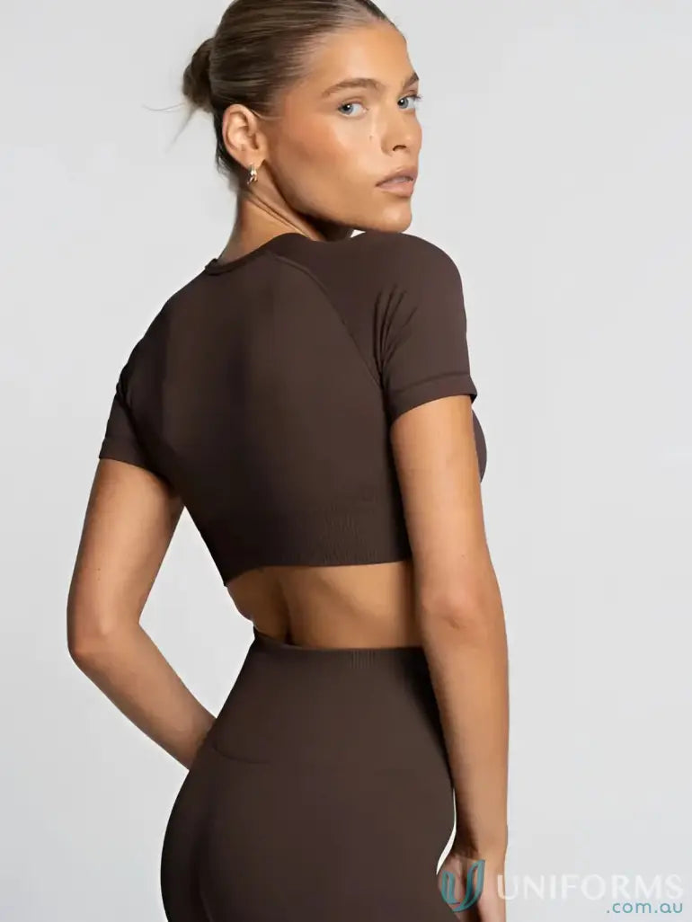 Brown cropped top with short sleeves and back cutout design.