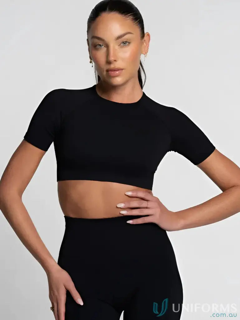 Black cropped athletic top with short sleeves and ribbed neckline.