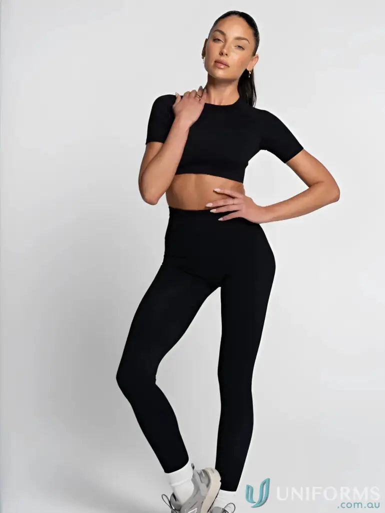 Black leggings with a high waist and ribbed texture, paired with white sneakers.